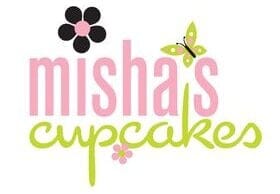 Logo for “misha’s cupcakes” features “misha’s” in pink lowercase letters and “cupcakes” in green script, decorated with a black flower, pink flower, and green butterfly—perfectly capturing the charm of locally baked sweets.